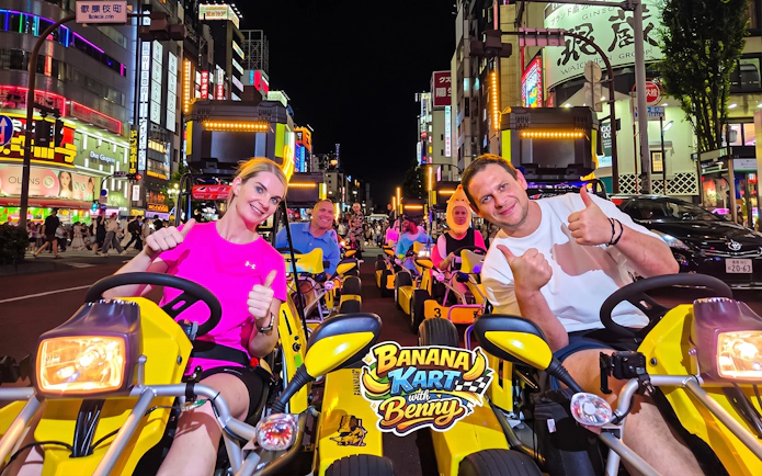 Participants in go-karts on the Banana Kart Tokyo tour from Shinjuku to Shibuya at night.