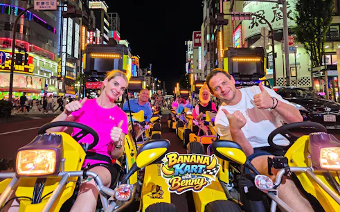 Participants in go-karts on the Banana Kart Tokyo tour from Shinjuku to Shibuya at night.