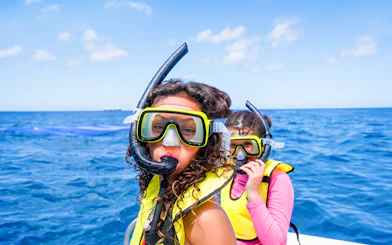 Kids preparing to snorkel in Waikoloa, Big Island, wearing snorkel gear on a boat.