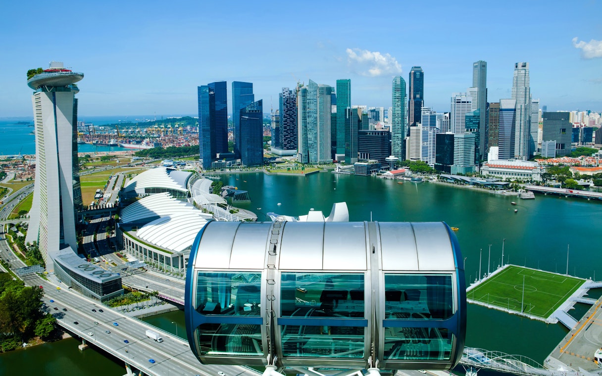 Singapore Flyer capsule overlooking Marina Bay and city skyline.