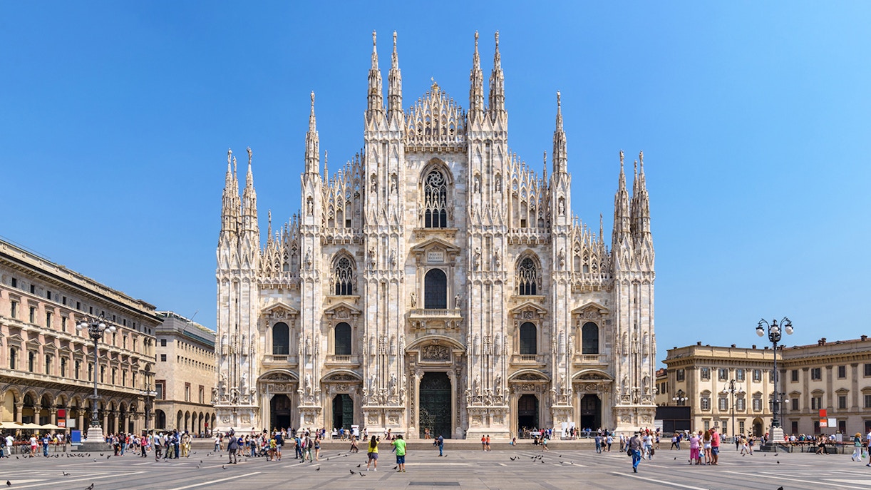 Duomo Milan Cathedral facade with tourists in the square, Italy.
