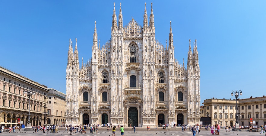 Duomo Milan Cathedral facade with tourists in the square, Italy.