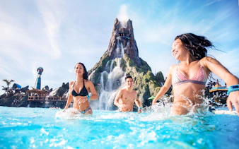 Guests enjoying the waterpark at Universal Studios Resort, Orlando, with a volcano backdrop.