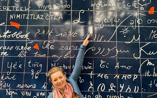 Person pointing at the "I Love You Wall" in Montmartre, Paris.
