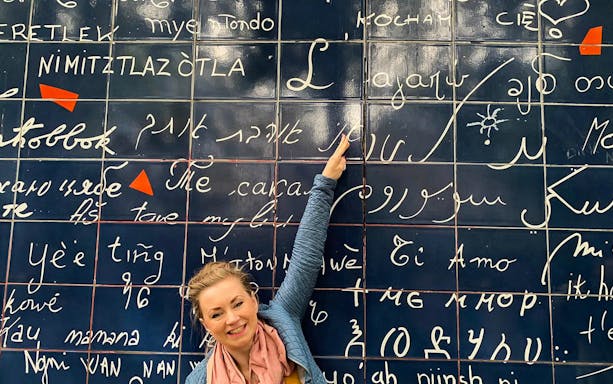 Person pointing at the "I Love You Wall" in Montmartre, Paris.
