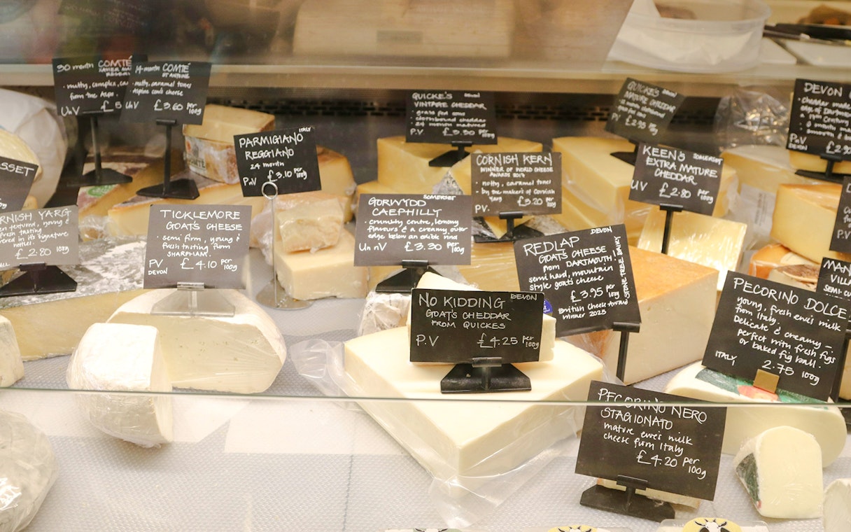 Assortment of cheeses with labels in Cheese Museum, Paris.