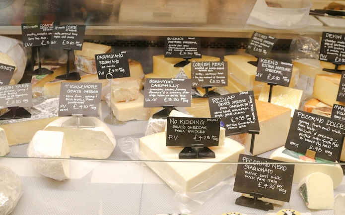 Assortment of cheeses with labels in Cheese Museum, Paris.