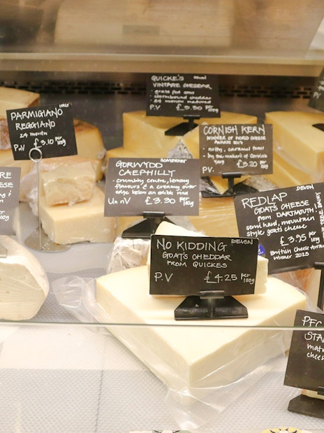 Assortment of cheeses with labels in Cheese Museum, Paris.