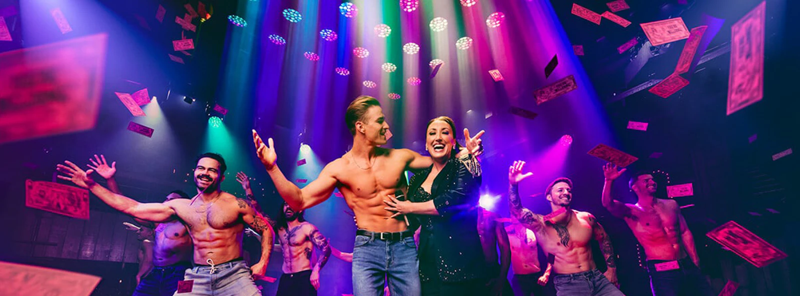 Performers on stage at Magic Mike Live show with colorful lights and confetti.