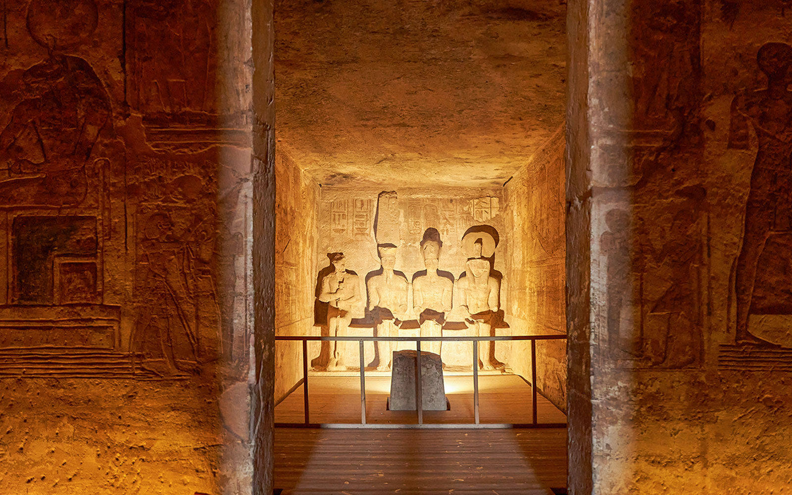 Abu Simbel Temple interior with illuminated statues of ancient Egyptian deities.