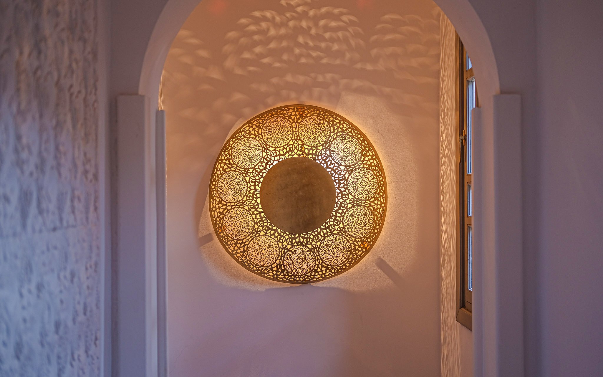 Ornate golden light fixture in a luxury steam hammam and spa hallway.