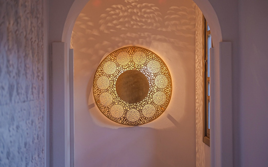 Ornate golden light fixture in a luxury steam hammam and spa hallway.