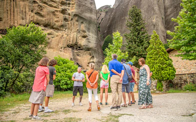 Tour guide explaining rock formations to tourists in Meteora, Greece.