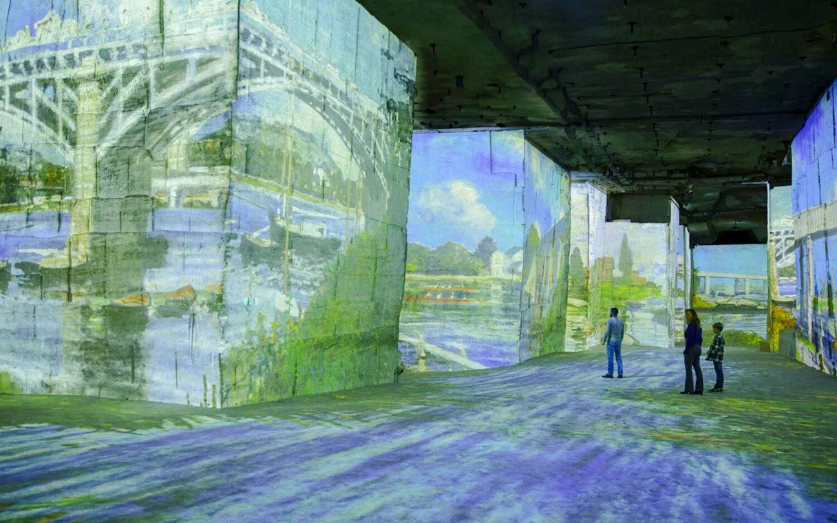 Monet projections at Carrières des Lumières with visitors viewing the immersive art display.