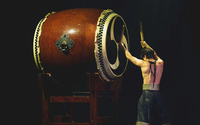 Performer playing large drum at DRUM TAO Theater in Kyoto.