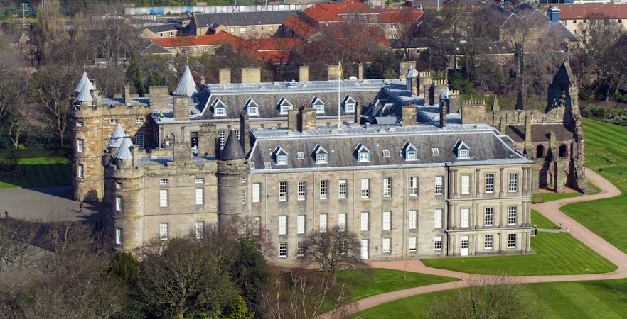 Aerial view of the Palace of Holyroodhouse in Edinburgh, showcasing its historic architecture and surrounding gardens.