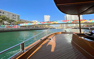 Boat cruising under colorful bridge in Sharjah canal tour.