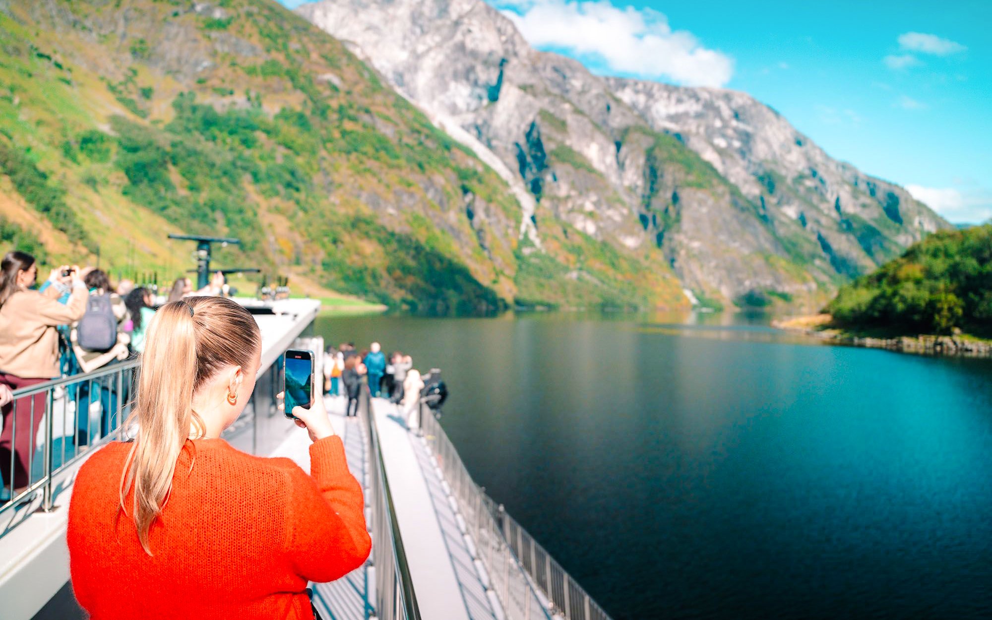 Guests taking photos on a boat during UNESCO Fjord Cruise in Norway.