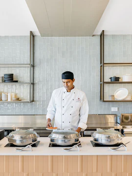 Chef preparing food at Plaza Premium Lounge Sydney buffet station.