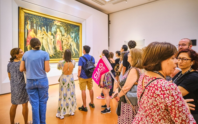 Visitors viewing Botticelli's "Primavera" on a guided tour at the Uffizi Gallery, Florence.
