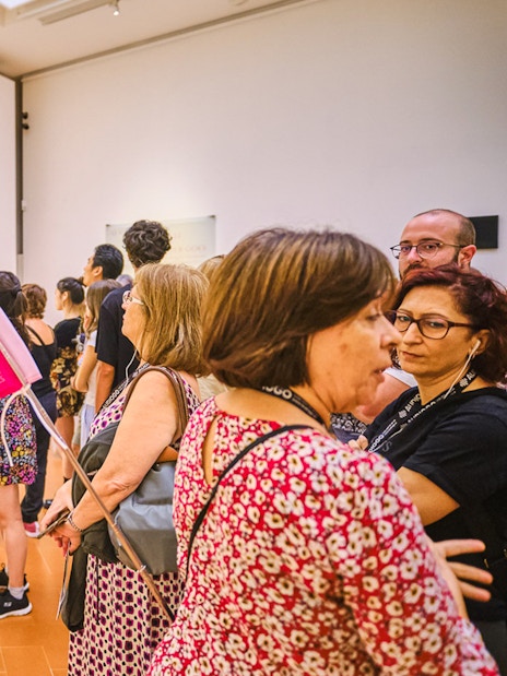 Visitors viewing Botticelli's "Primavera" on a guided tour at the Uffizi Gallery, Florence.