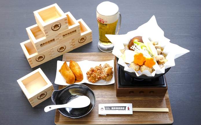 Sumo Show dining set with chicken hot pot, fried snacks, and beer in Asakusa, Japan.