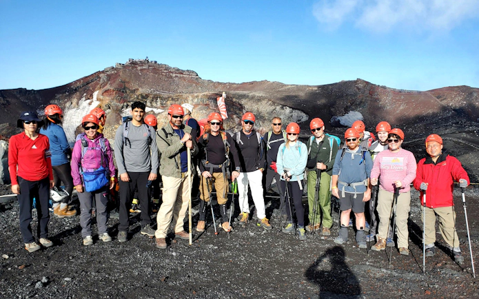 Group of hikers with helmets on Mt. Fuji climbing tour, Japan.