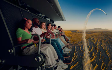 Group enjoying Flyover Chicago experience with aerial view of landscape and airplane trail.