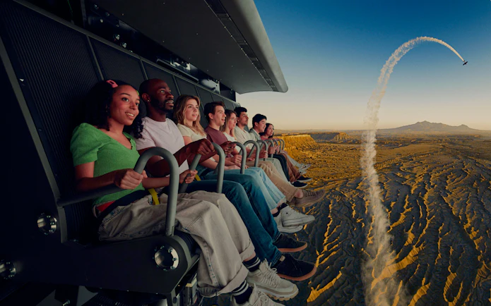 Group enjoying Flyover Chicago experience with aerial view of landscape and airplane trail.