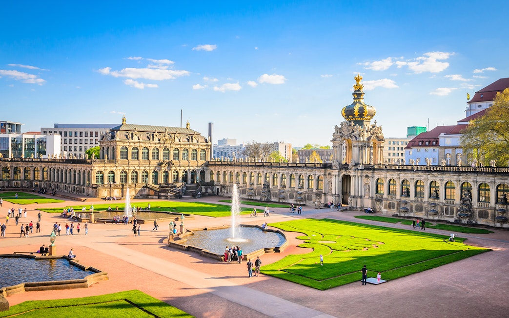Zwinger Building courtyard with fountains and visitors in Dresden, Germany.