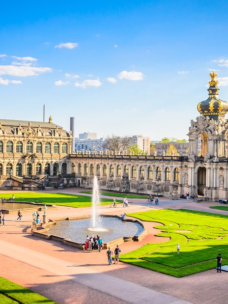 Zwinger Building courtyard with fountains and visitors in Dresden, Germany.