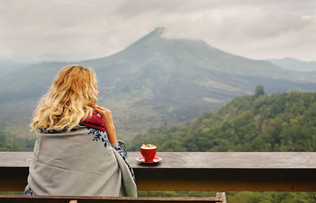 Woman enjoying coffee with a view of Mount Batur
