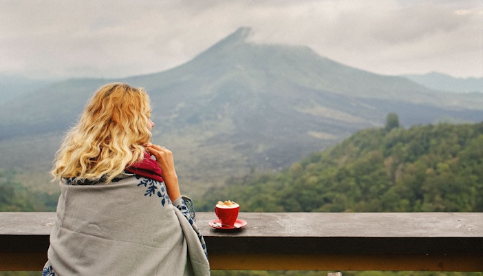 Woman enjoying coffee with view of mount batur