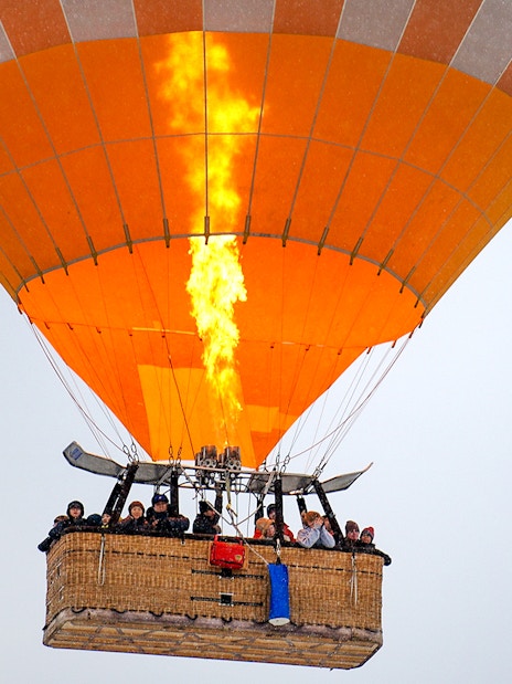Hot air balloon with passengers in Cappadocia during sunrise tour.