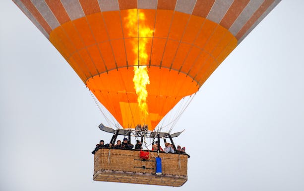 Hot air balloon with passengers in Cappadocia during sunrise tour.