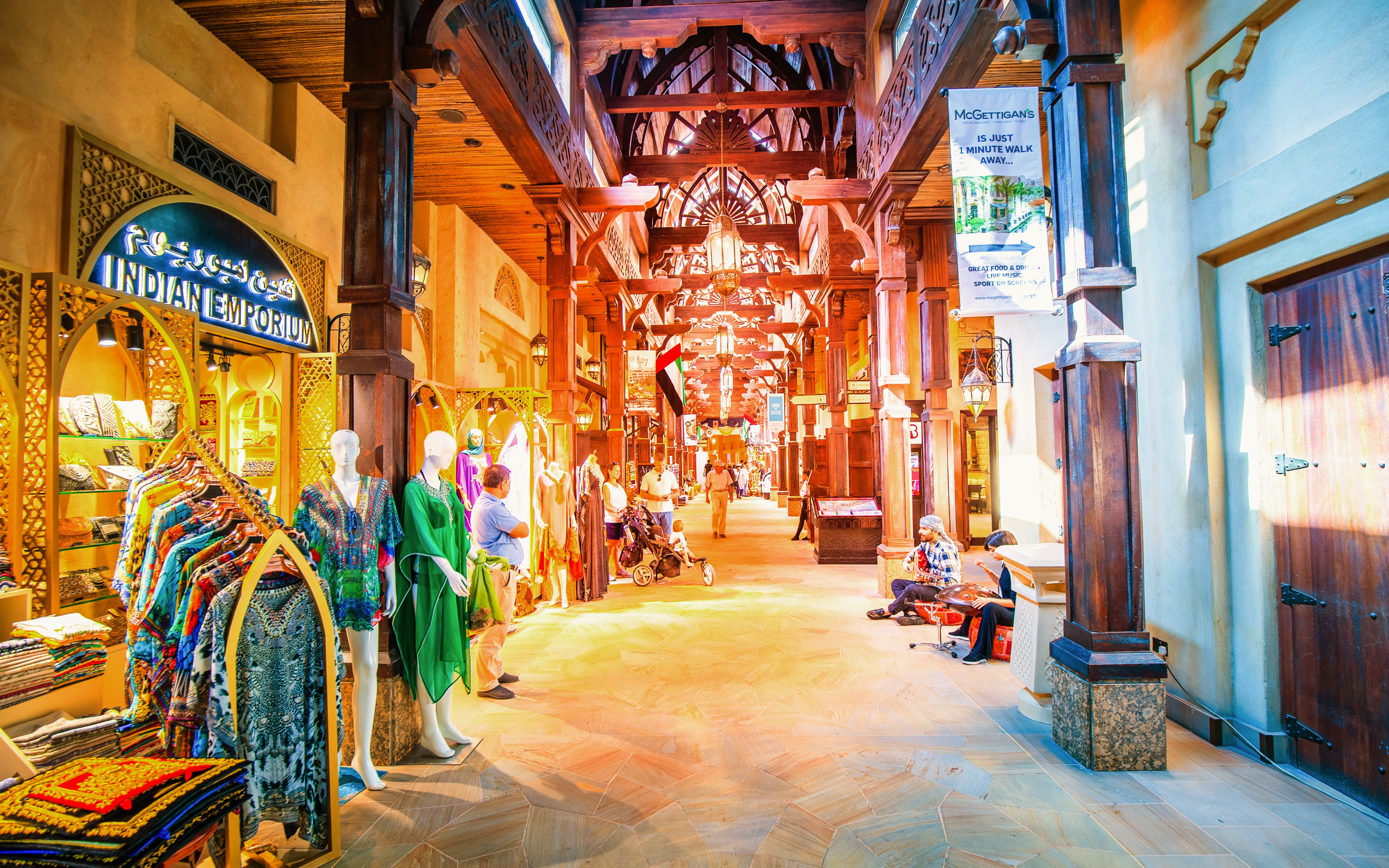 Bustling souk at night with colorful garments and wooden architecture in Dubai.