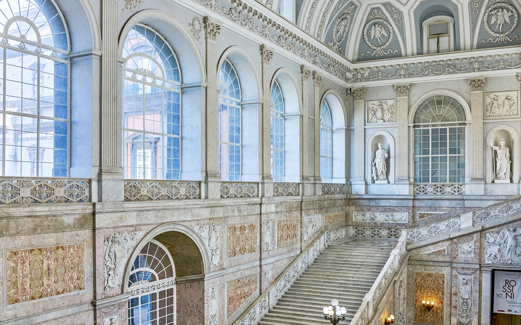 Grand staircase and ornate windows inside the Royal Palace of Naples.