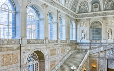 Grand staircase and ornate windows inside the Royal Palace of Naples.