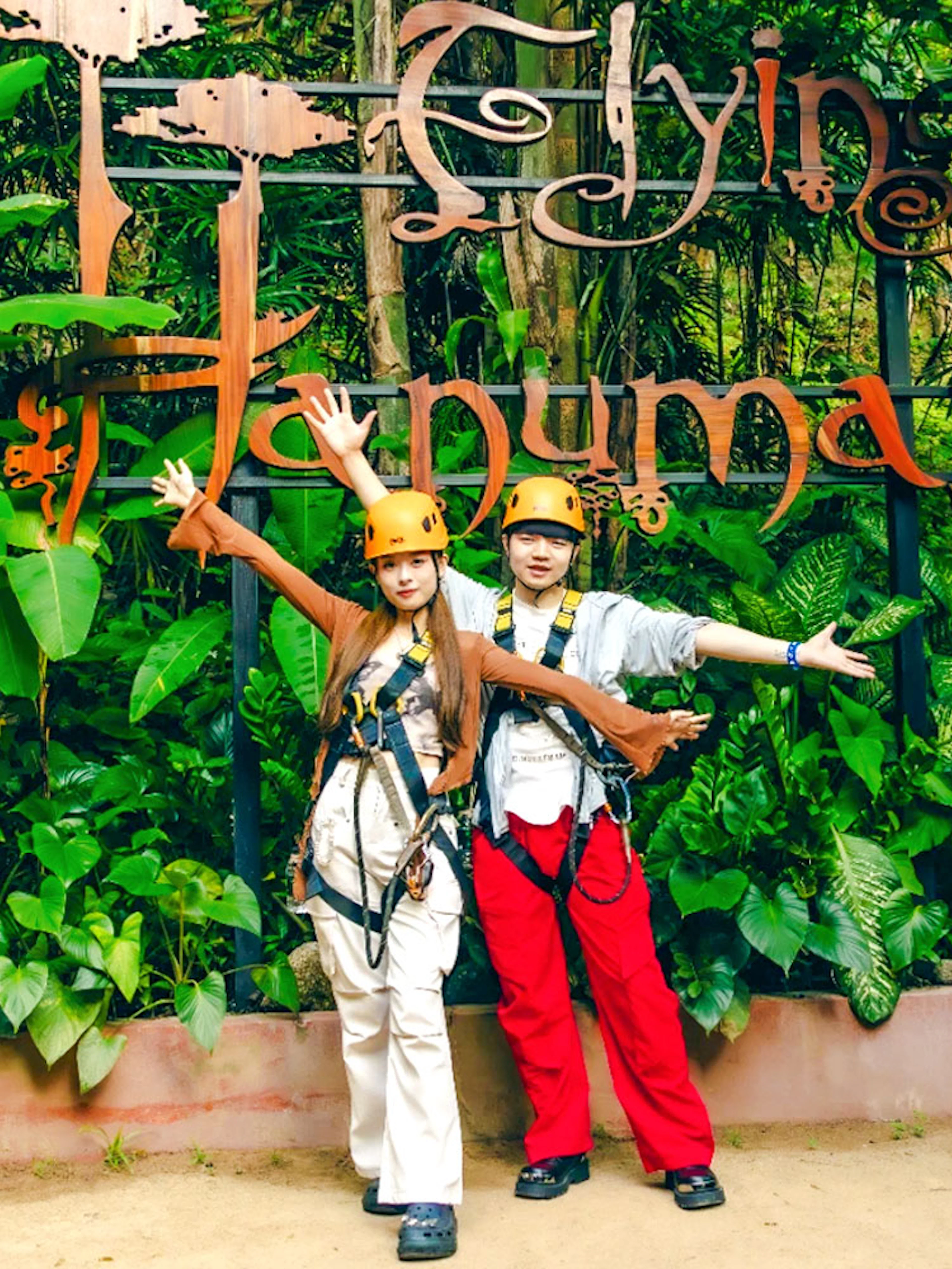 Participants in safety gear at Flying Hanuman zipline, surrounded by lush greenery.
