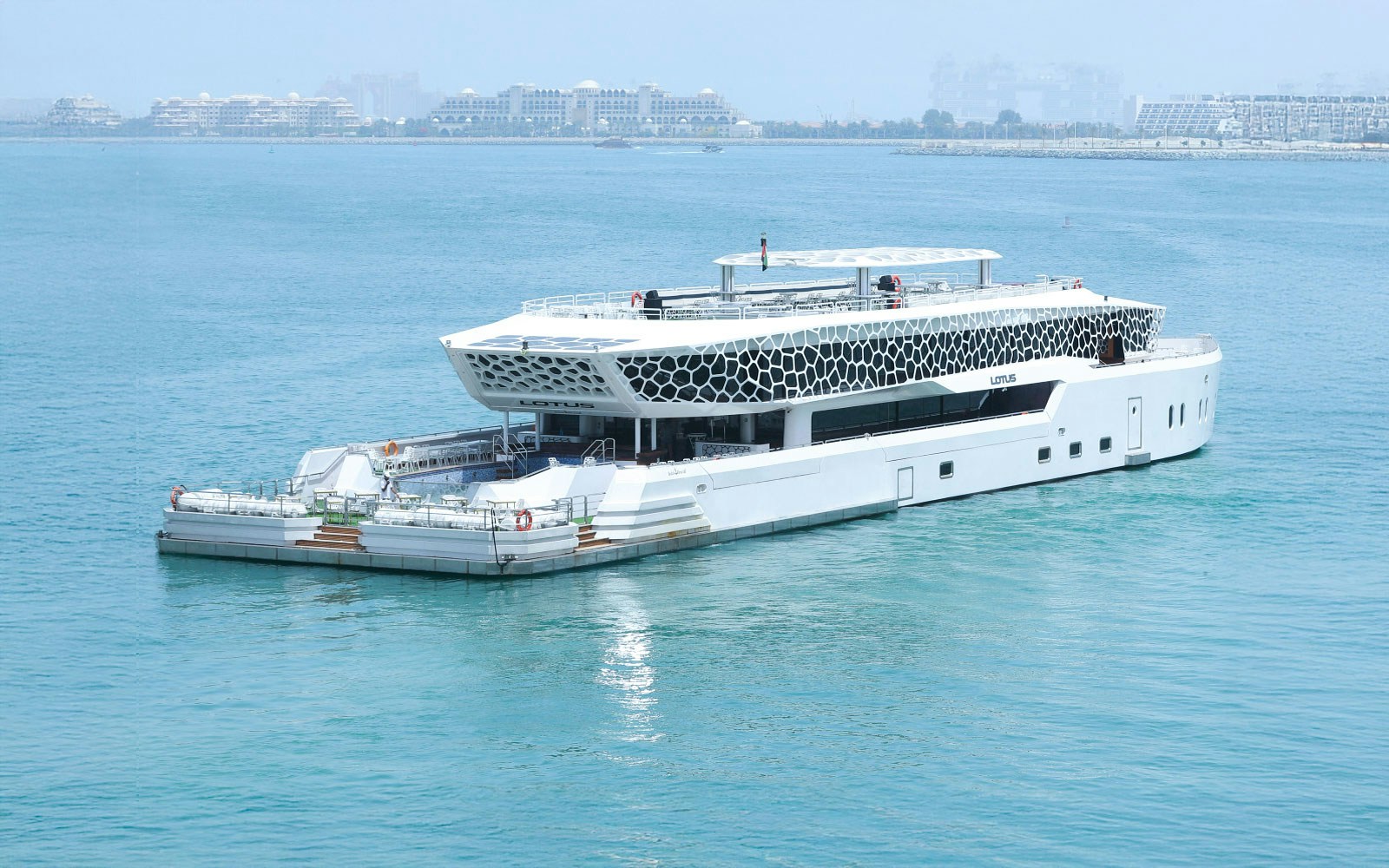 Lotus Mega Yacht cruising Dubai Marina with buffet dinner setup and live entertainment.