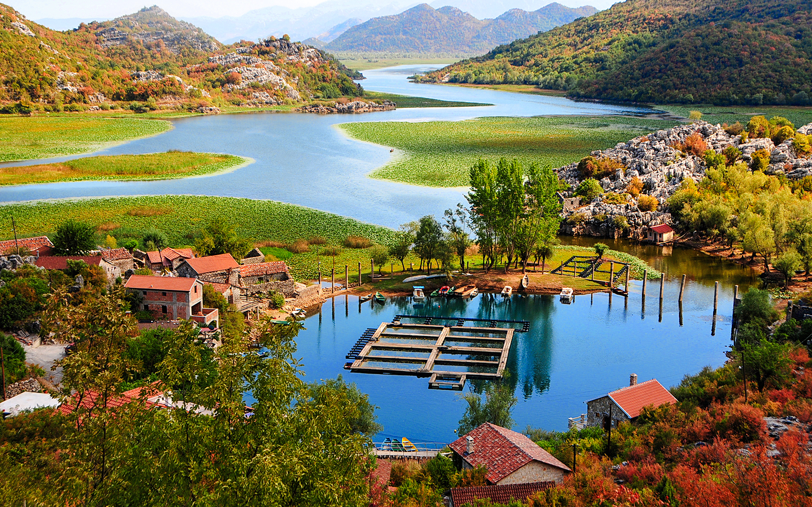 Karuč village by Skadar Lake, Montenegro, with boats and lush landscape.