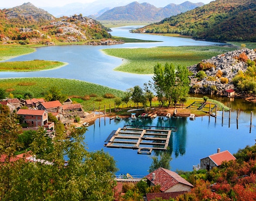 Karuč village by Skadar Lake, Montenegro, with boats and lush landscape.