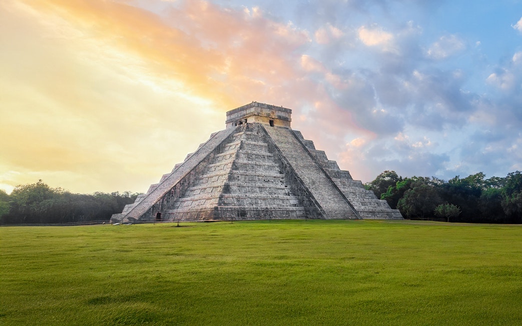 Chichen Itza Pyramid at sunrise, Yucatan, with a clear sky backdrop.