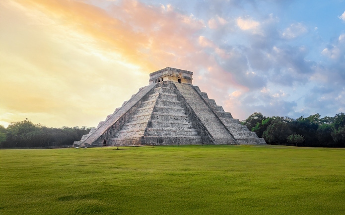 Chichen Itza Pyramid at sunrise, Yucatan, with a clear sky backdrop.