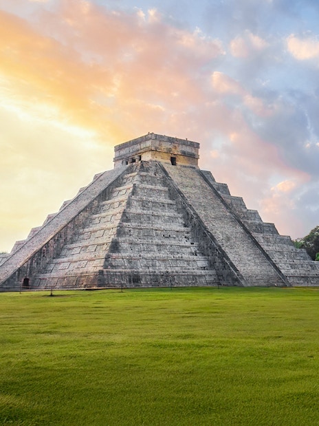 Chichen Itza Pyramid at sunrise, Yucatan, with a clear sky backdrop.