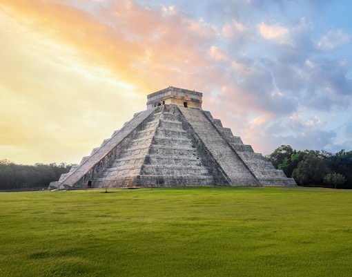Chichen Itza Pyramid at sunrise, Yucatan, with a clear sky backdrop.