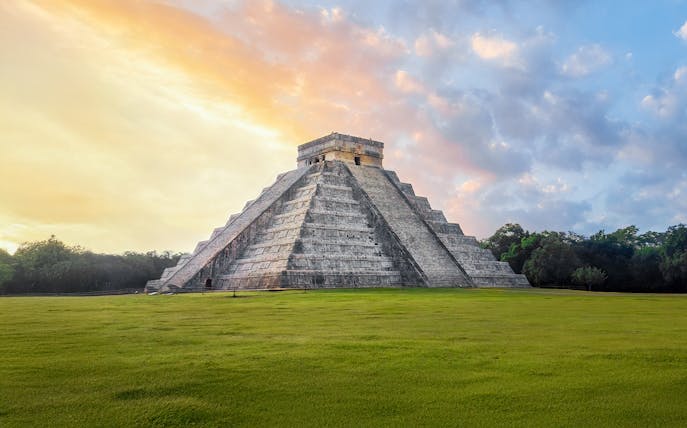 Chichen Itza Pyramid at sunrise, Yucatan, with a clear sky backdrop.