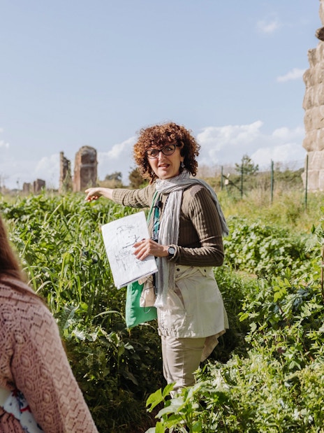 Guide explaining Roman aqueducts on the Appian Way during an underground Rome catacombs tour.