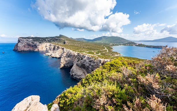 Alghero coastline with cliffs and sea view on guided e-bike tour route.