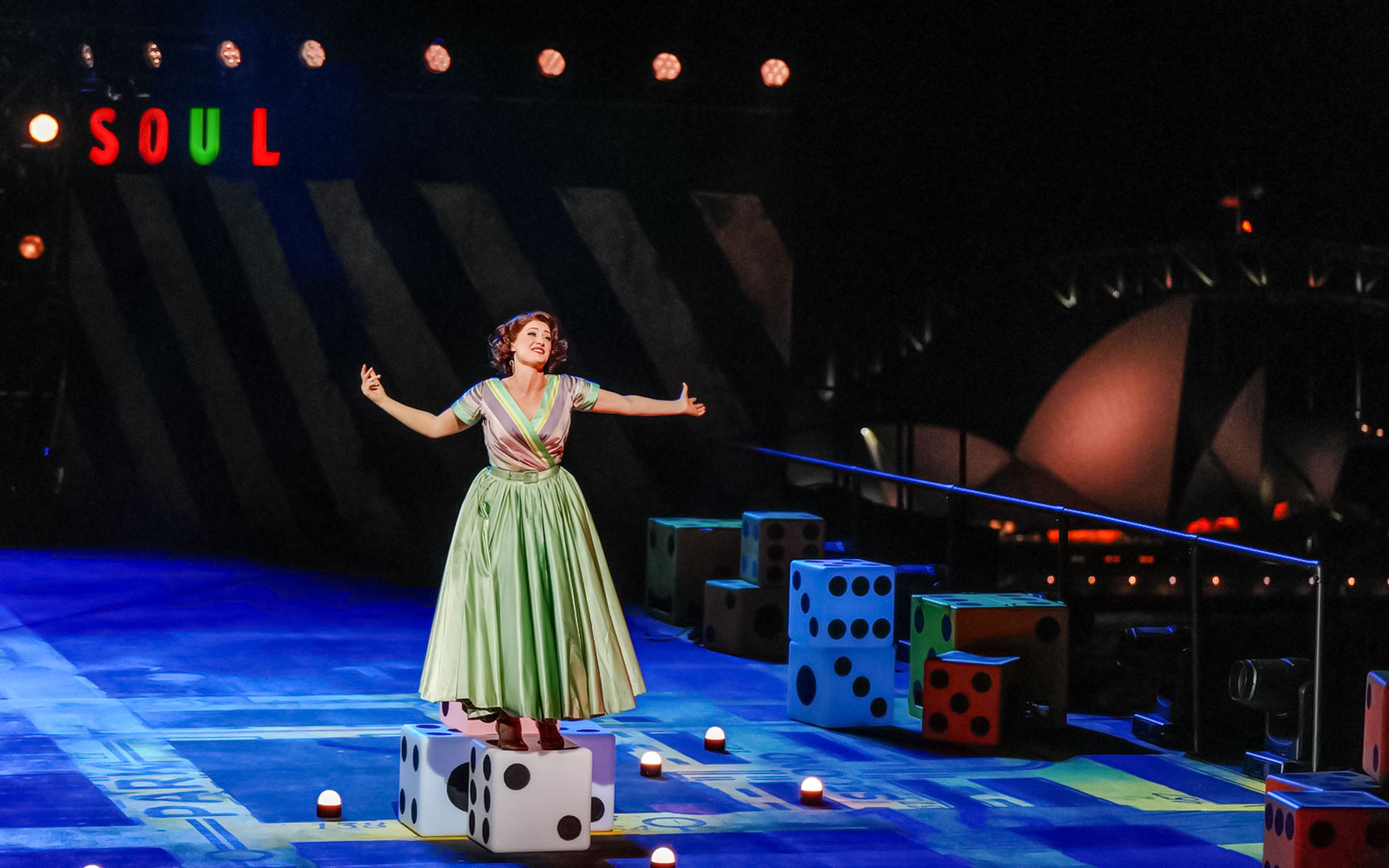Performer on stage during "Guys & Dolls" at Sydney Harbour with Sydney Opera House in background.